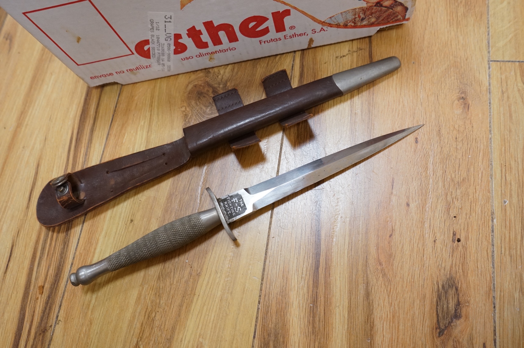 A Sykes-Fairburn Fighting Knife by Wilkinson sword in its leather scabbard, together with a 1942 Mk.III military compass by T.G.Co.Ltd. in a webbing pouch dated 1940, together with another compass, a telescope in a leath